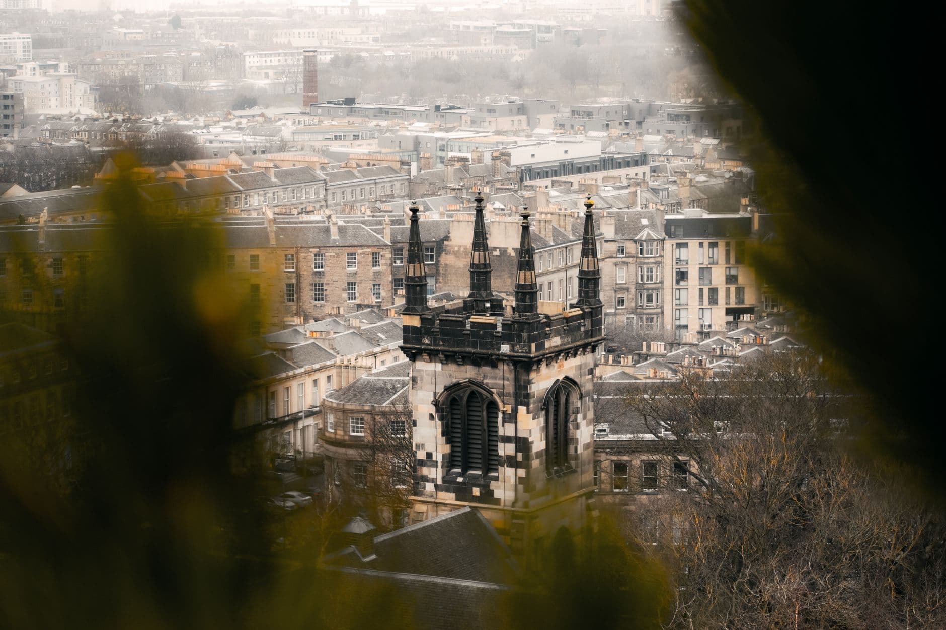 Aerial view of Edinburgh's historic architecture on a moody day, showcasing iconic towers.