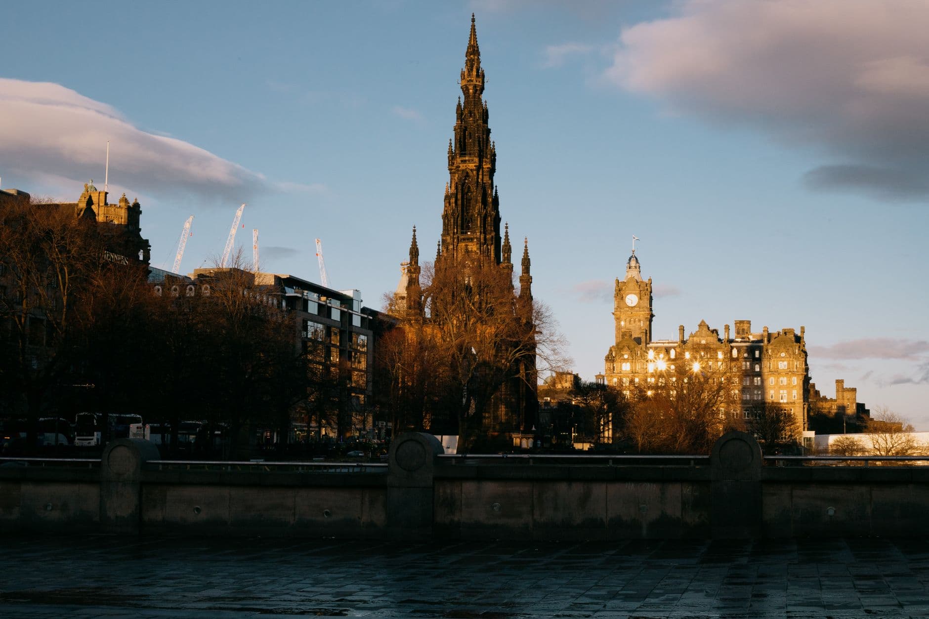Iconic Scott Monument and Edinburgh skyline at dusk, capturing gothic architecture and urban landscape.